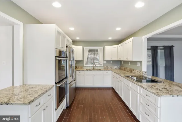 a large kitchen with stainless steel appliances granite countertop a large counter top and a stove