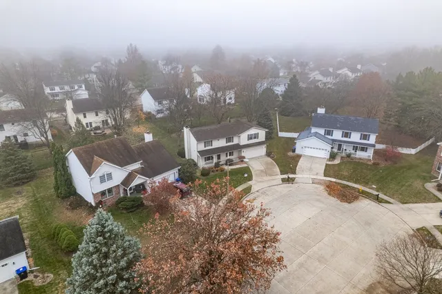 an aerial view of a house with yard and mountain view in back