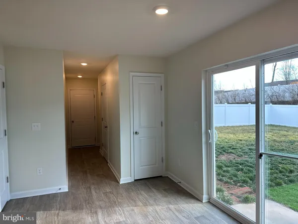a view of hallway with a large window and wooden floor