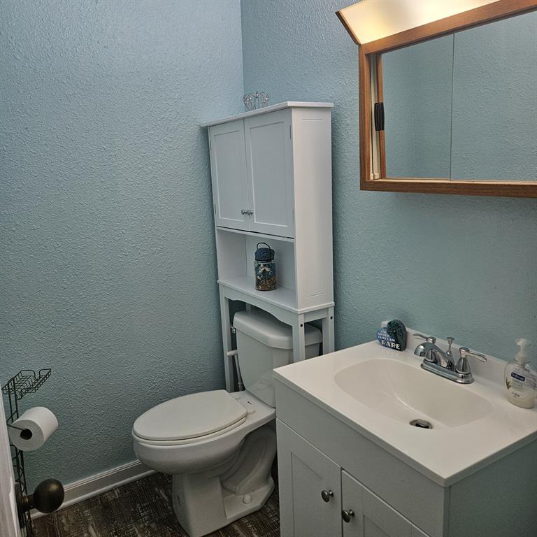608 North Colorado Street Whitney, TX 76692 - Photo 21 of 27 a bathroom with a sink a toilet and mirror