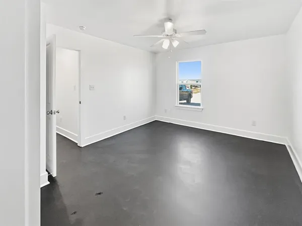 an empty room with a ceiling fan and a window