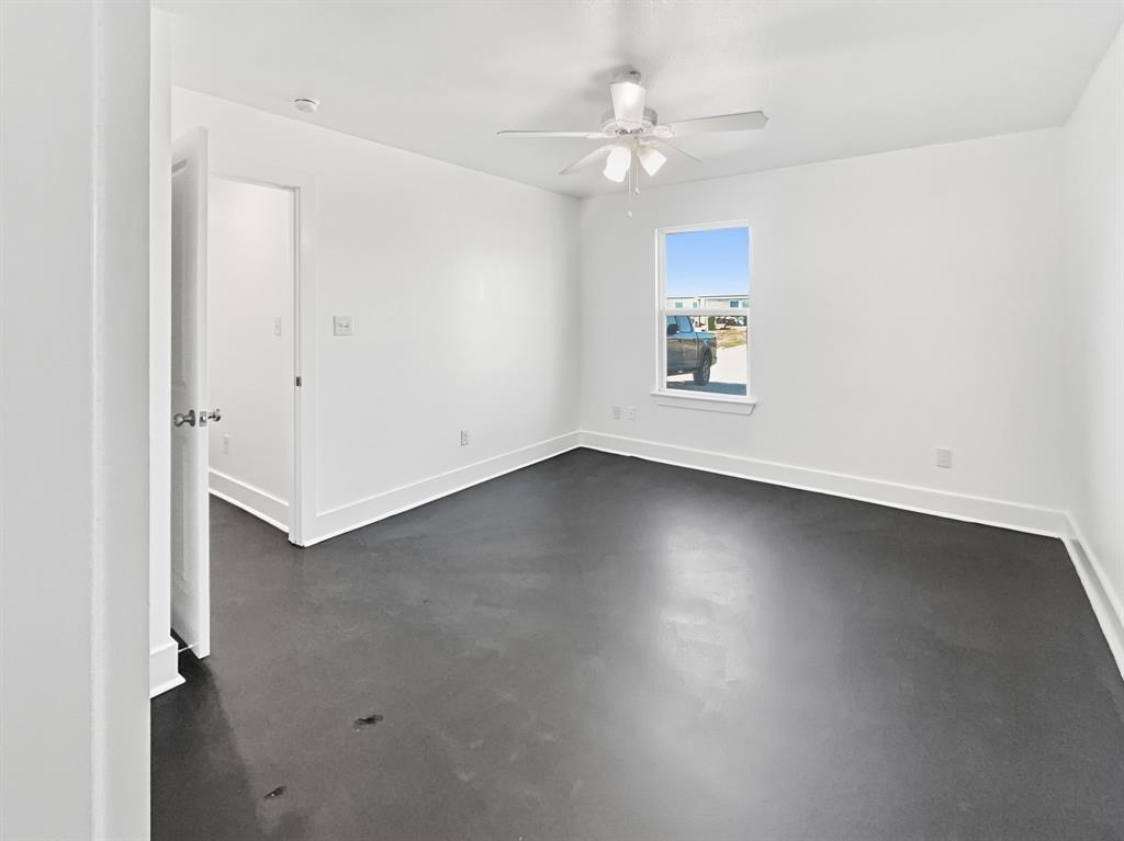 109 James Street, Unit 200 Decatur, TX 76234 - Photo 16 of 21 an empty room with a ceiling fan and a window