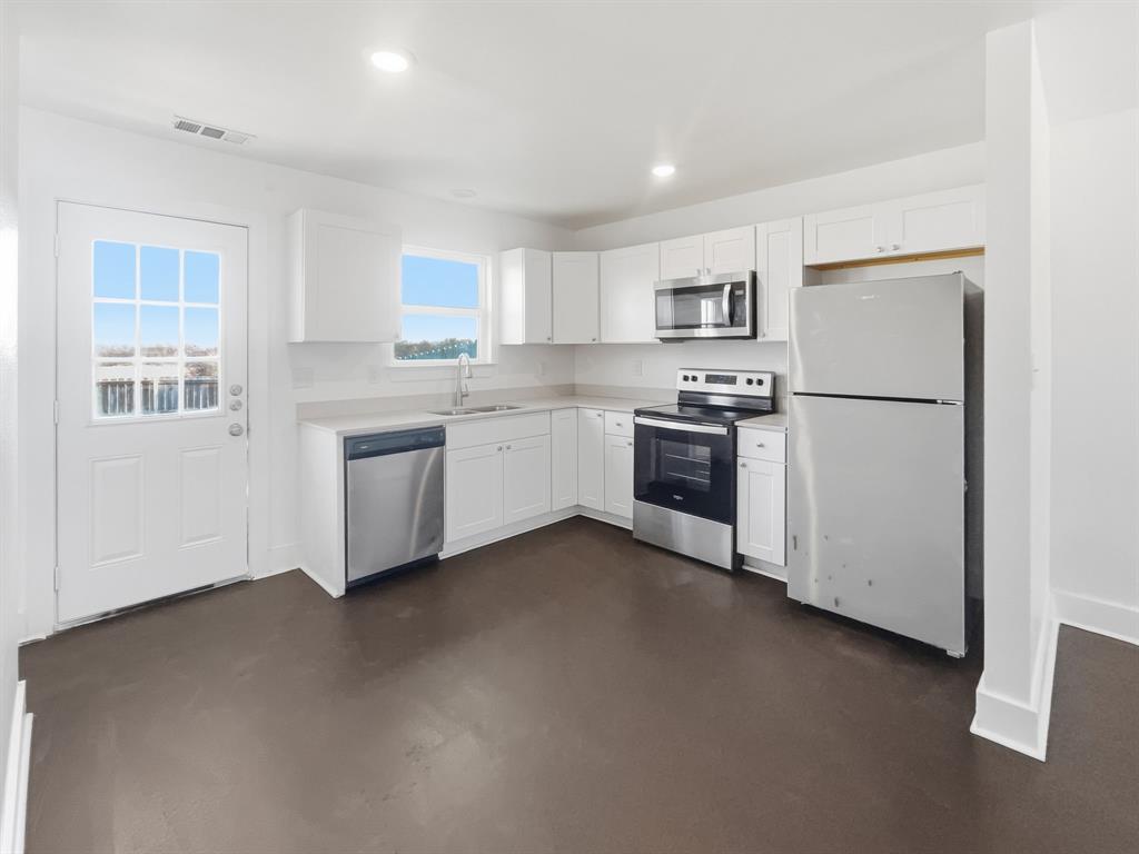 109 James Street, Unit 200 Decatur, TX 76234 - Photo 5 of 21 a kitchen with white cabinets and white appliances