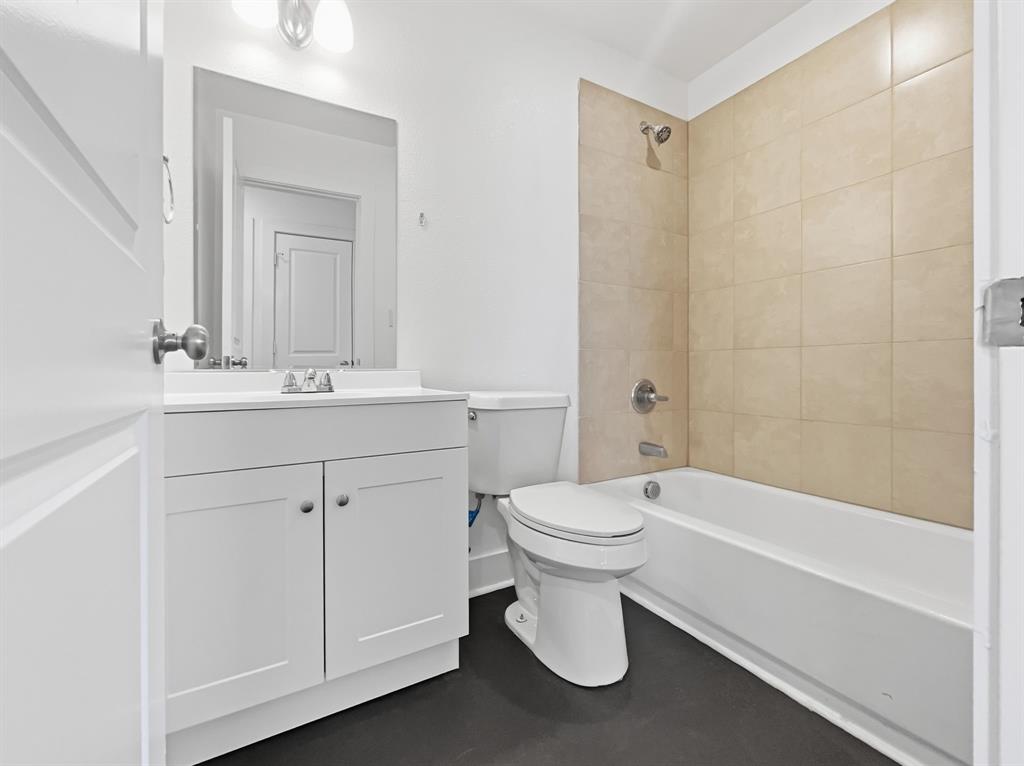 109 James Street, Unit 200 Decatur, TX 76234 - Photo 8 of 21 a bathroom with a white toilet sitting next to a bathroom sink and a shower