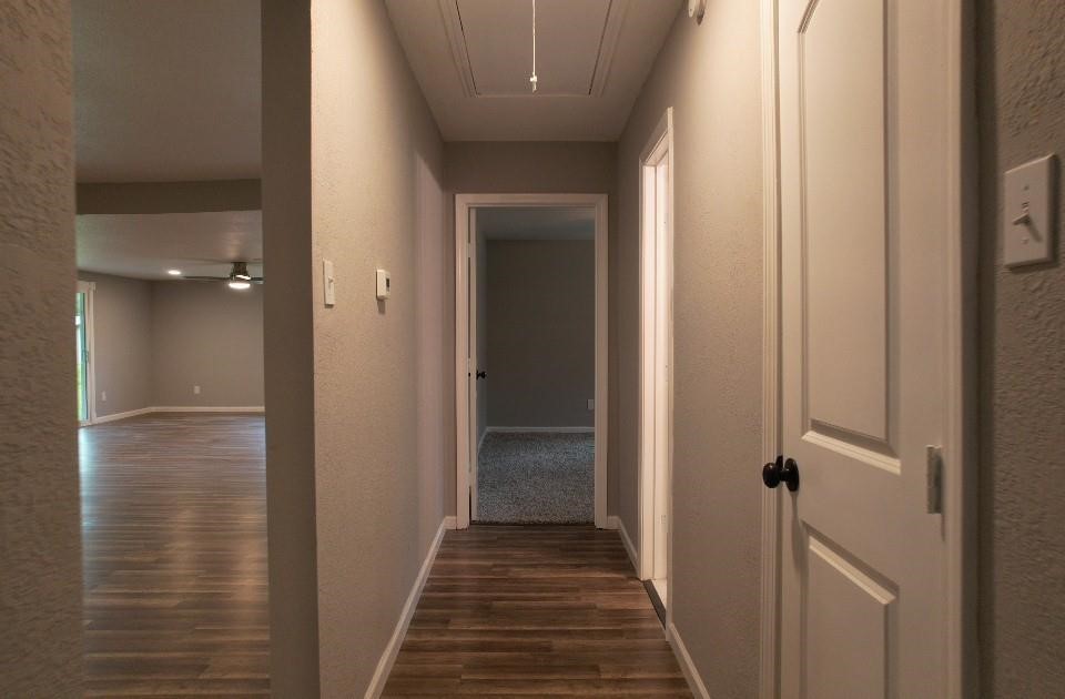 25373 Goodson Road Splendora, TX 77372 - Photo 30 of 43 Inviting hallway with wood flooring and a ceiling fan, enhancing the space's design. Perfect for showcasing the property's charm and seamlessly connecting rooms within the home.