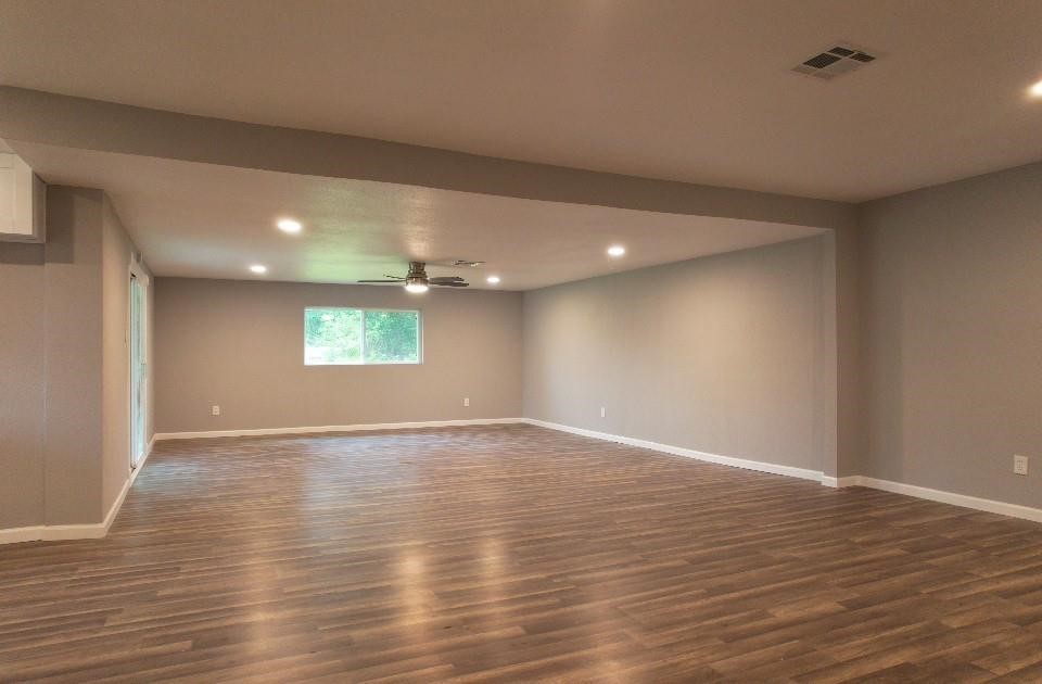 25373 Goodson Road Splendora, TX 77372 - Photo 3 of 43 Charming room with hardwood floors and a modern ceiling fan. The warm wood tones create a cozy atmosphere, perfect for relaxing or entertaining. A great space to showcase your interior design style.