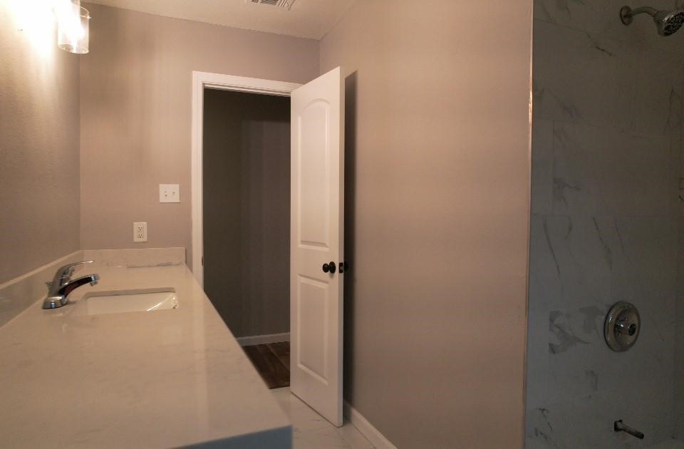 25373 Goodson Road Splendora, TX 77372 - Photo 31 of 43 This bathroom features a white door, modern fixtures, and an elegant design. With a sink, bathtub, and stylish tiles, it offers a comfortable and inviting space—perfect for relaxation.