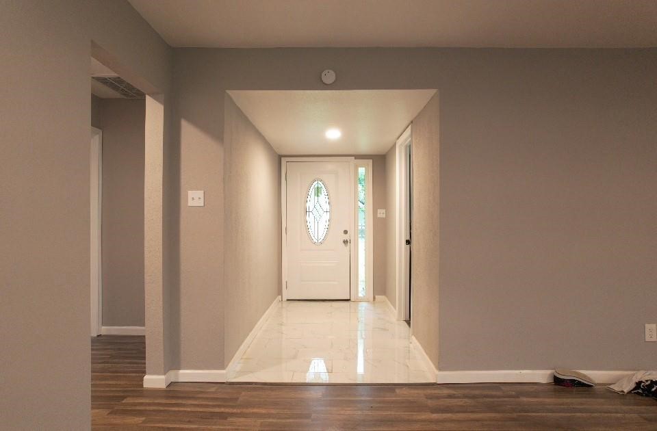 25373 Goodson Road Splendora, TX 77372 - Photo 35 of 43 This hallway features a white door, laminate and hardwood flooring, plaster walls, and decorative molding. The modern design creates an appealing space, perfect for attracting potential buyers.