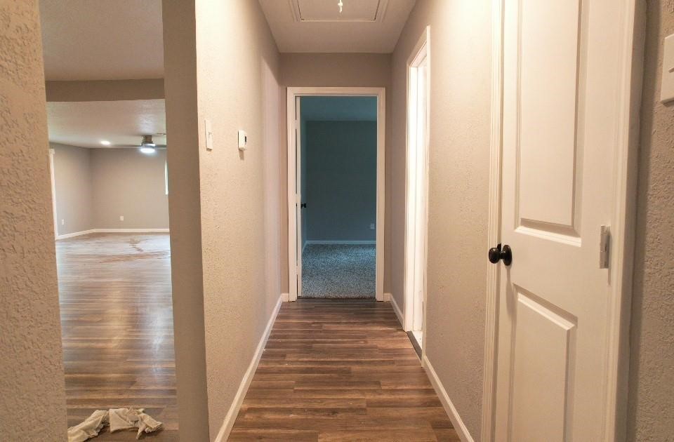 25373 Goodson Road Splendora, TX 77372 - Photo 37 of 43 Inviting hallway with wood flooring, a classic door, and elegant molding.