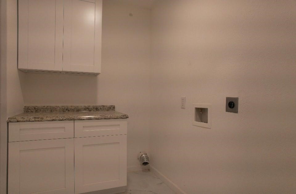 25373 Goodson Road Splendora, TX 77372 - Photo 39 of 43 Inviting space with modern white cabinets, countertops, and a washing machine. Featuring tiled flooring and ample storage, it's perfect for a laundry room remodel with a clean, contemporary design.
