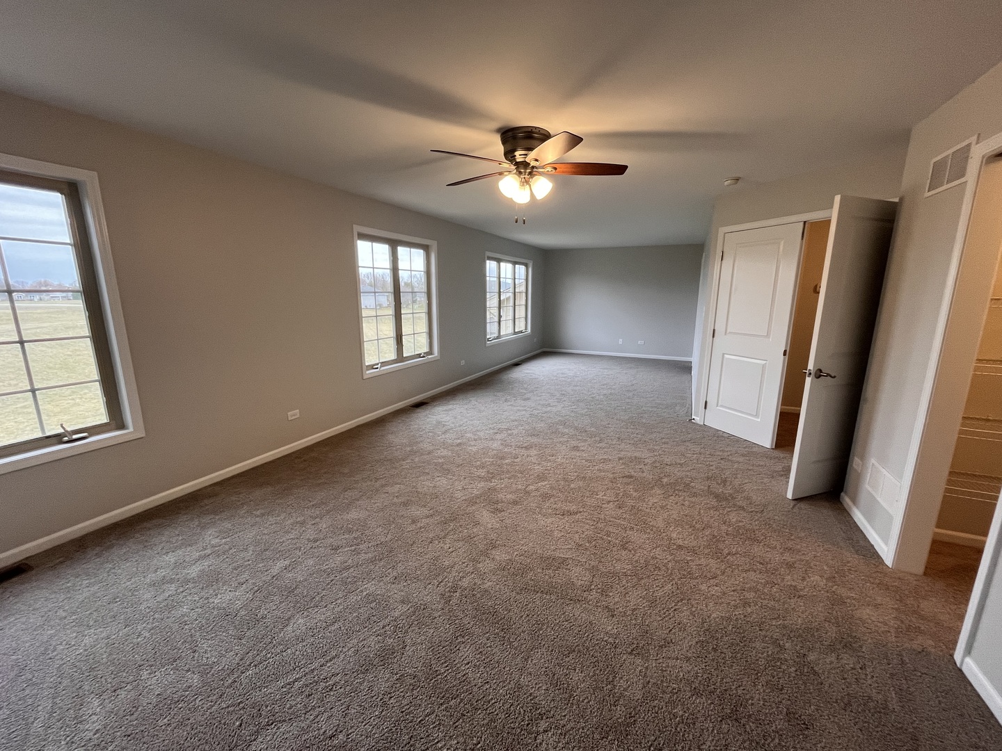 402 Chestnut Lane Beecher, IL 60401 - Photo 16 of 23 an empty room with chandelier fan and windows