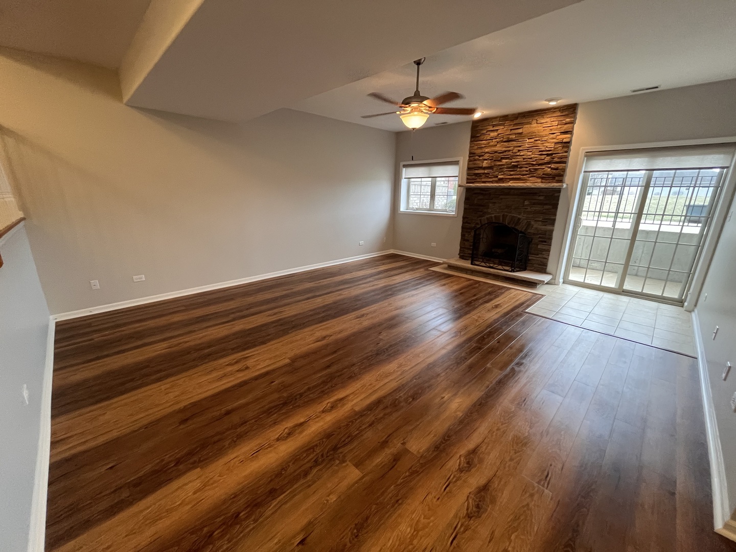 402 Chestnut Lane Beecher, IL 60401 - Photo 7 of 23 an empty room with wooden floor fireplace and windows