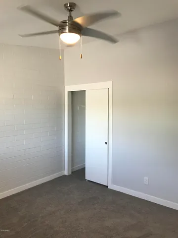 an empty room with chandelier fan