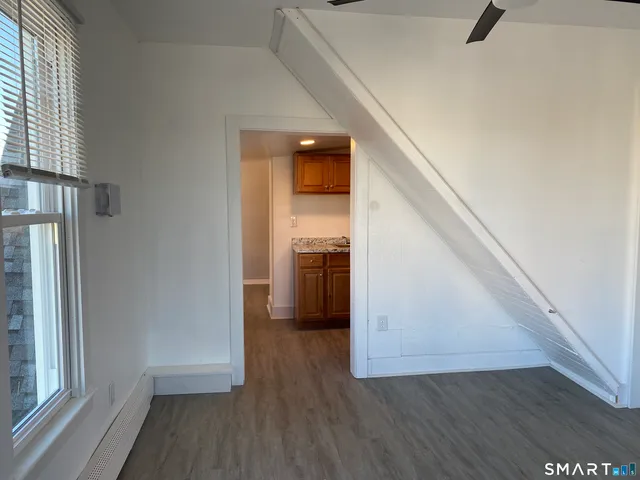 a view of a hallway view with wooden floor and staircase