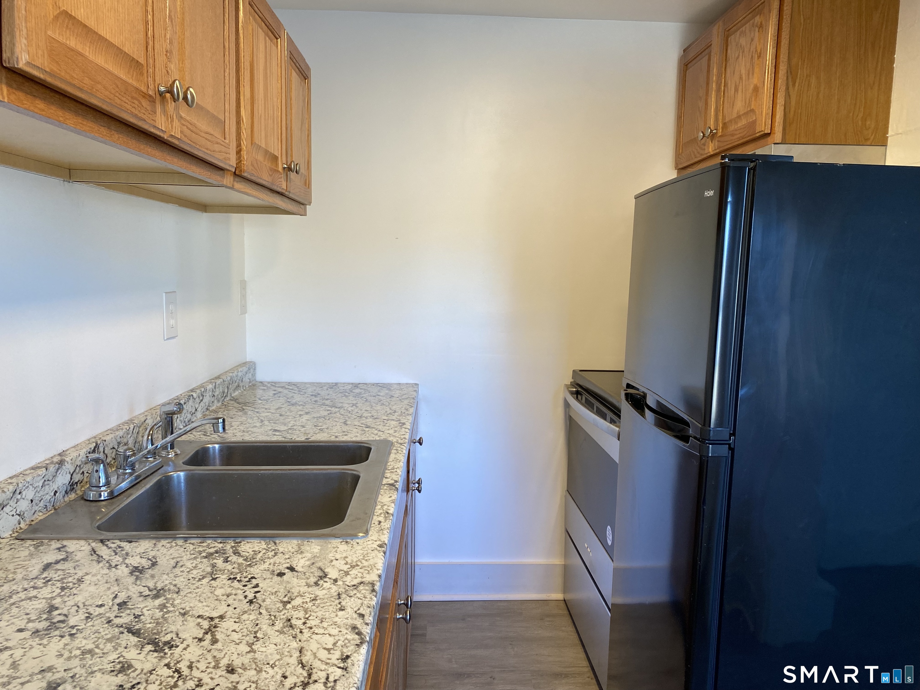 26 Prospect Street, Unit 9 New London, CT 06320 - Photo 7 of 12 a kitchen with a sink a refrigerator and cabinets