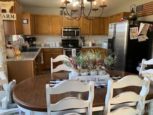 203 Kimball Road Concord, VA 24538 - Photo 6 of 27 a kitchen with stainless steel appliances granite countertop a sink dishwasher a dining table and chairs with wooden floor
