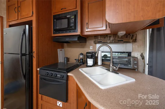 a kitchen with granite countertop a sink stainless steel appliances and cabinets