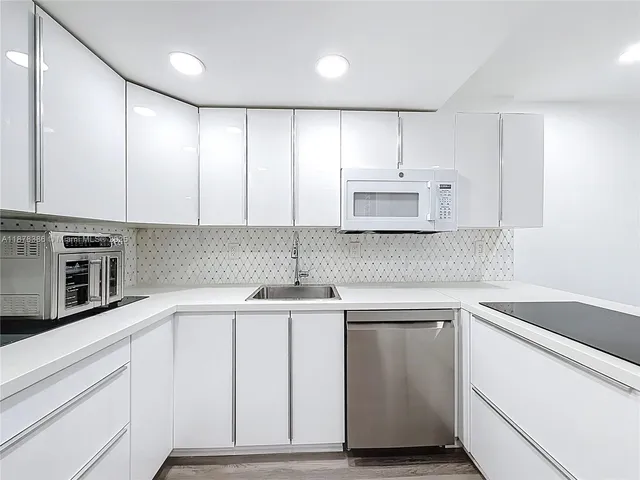 a kitchen with granite countertop white cabinets and white appliances