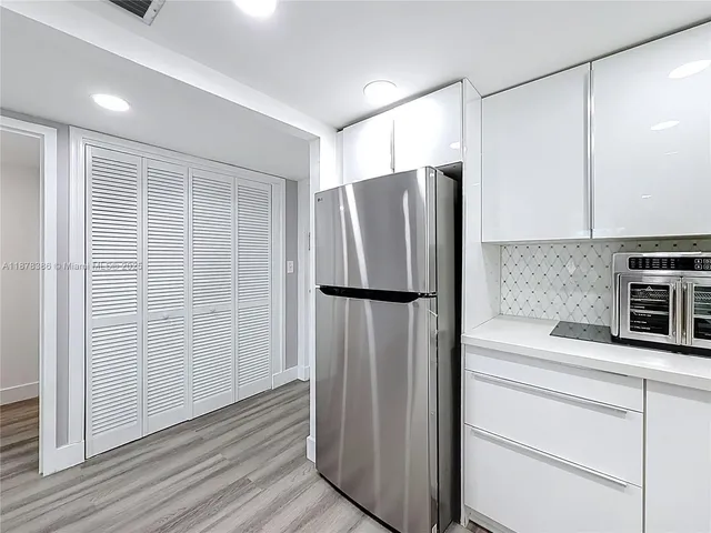 a kitchen with stainless steel appliances a refrigerator and cabinets