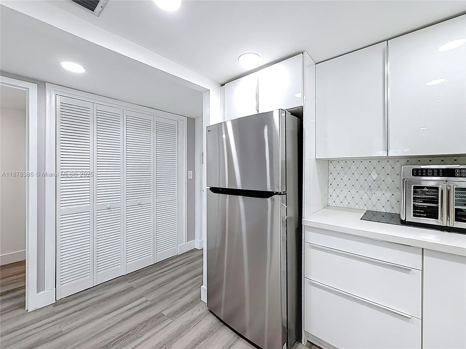 17620 Atlantic Boulevard, Unit 505 Sunny Isles Beach, FL 33160 - Photo 13 of 35 a kitchen with stainless steel appliances a refrigerator and cabinets