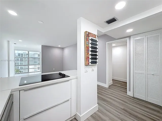a kitchen with granite countertop a sink and a wooden floor