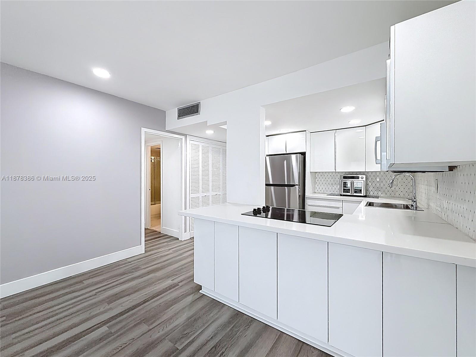 17620 Atlantic Boulevard, Unit 505 Sunny Isles Beach, FL 33160 - Photo 17 of 35 a kitchen with white cabinets sink and refrigerator