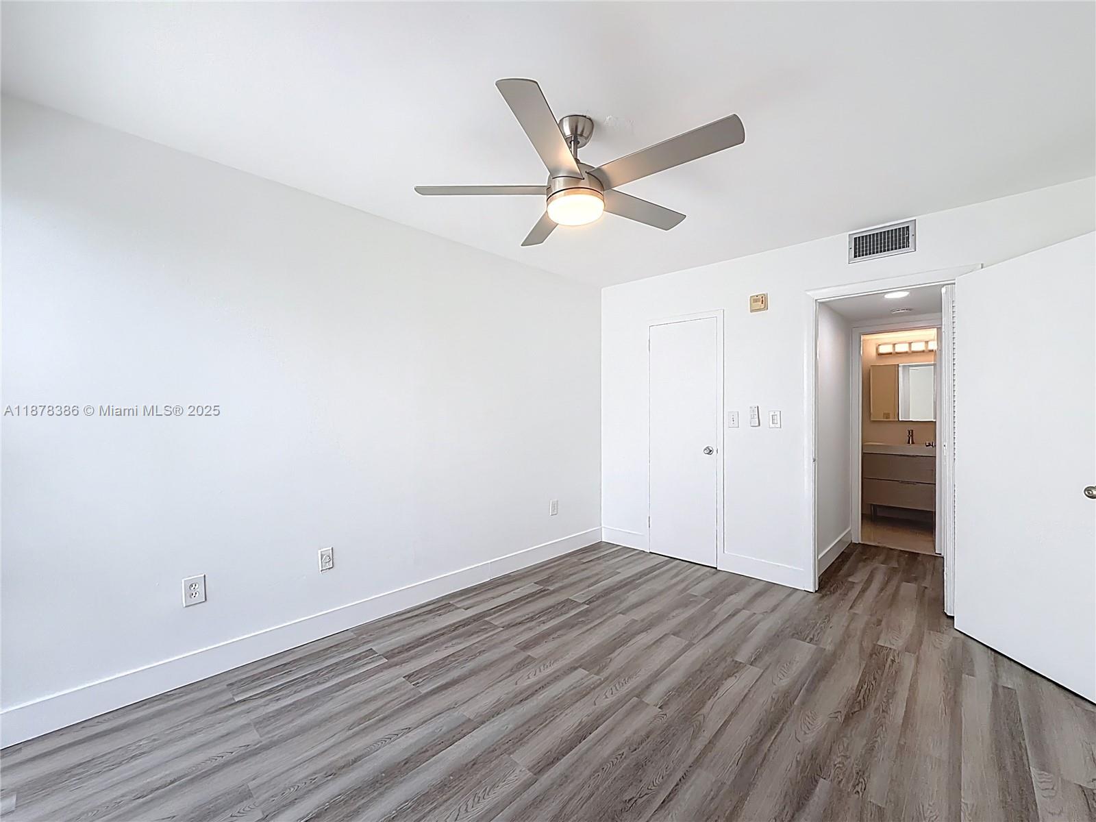 17620 Atlantic Boulevard, Unit 505 Sunny Isles Beach, FL 33160 - Photo 23 of 35 an empty room with wooden floor and windows