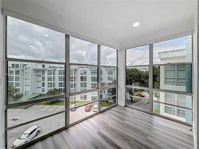 a view of a large room with wooden floor and windows