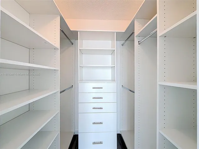 a view of walk in closet with empty racks