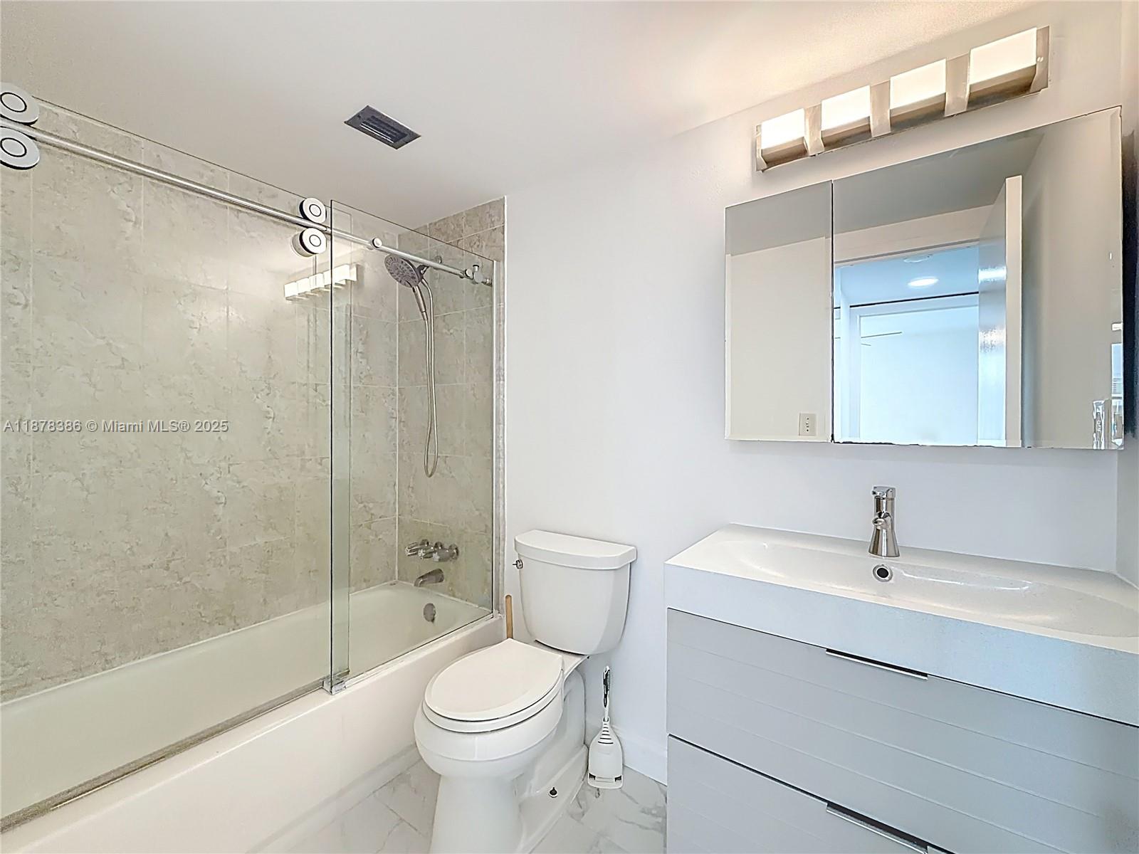 17620 Atlantic Boulevard, Unit 505 Sunny Isles Beach, FL 33160 - Photo 30 of 35 a bathroom with a toilet a sink a mirror and shower