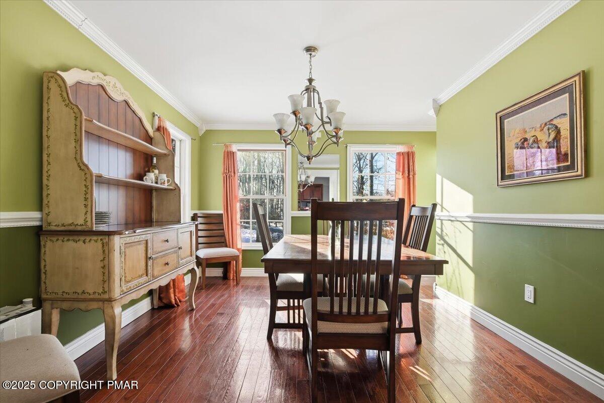 106 Ashley Court Bushkill, PA 18324 - Photo 18 of 61 a view of a dining room with furniture a chandelier and wooden floor