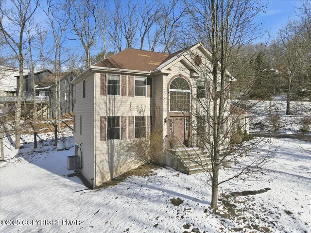 a front view of a house with a yard covered in snow