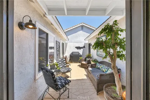 a view of a porch with chairs and potted plants