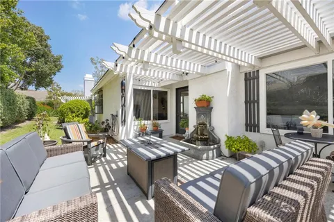 a view of a patio with couches table and chairs and potted plants