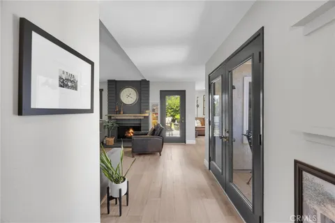 a view of a hallway to a livingroom with furniture wooden floor and window