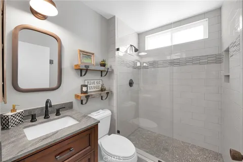 a bathroom with a granite countertop sink mirror and toilet
