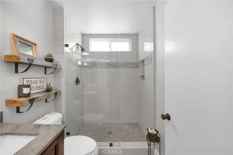 a bathroom with a granite countertop sink a toilet and shower