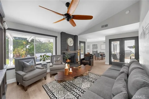 a living room with furniture ceiling fan and a large window