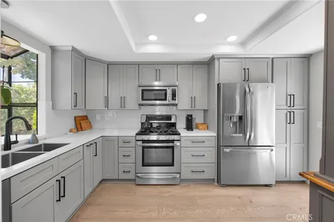 a kitchen with stainless steel appliances granite countertop a refrigerator sink and stove