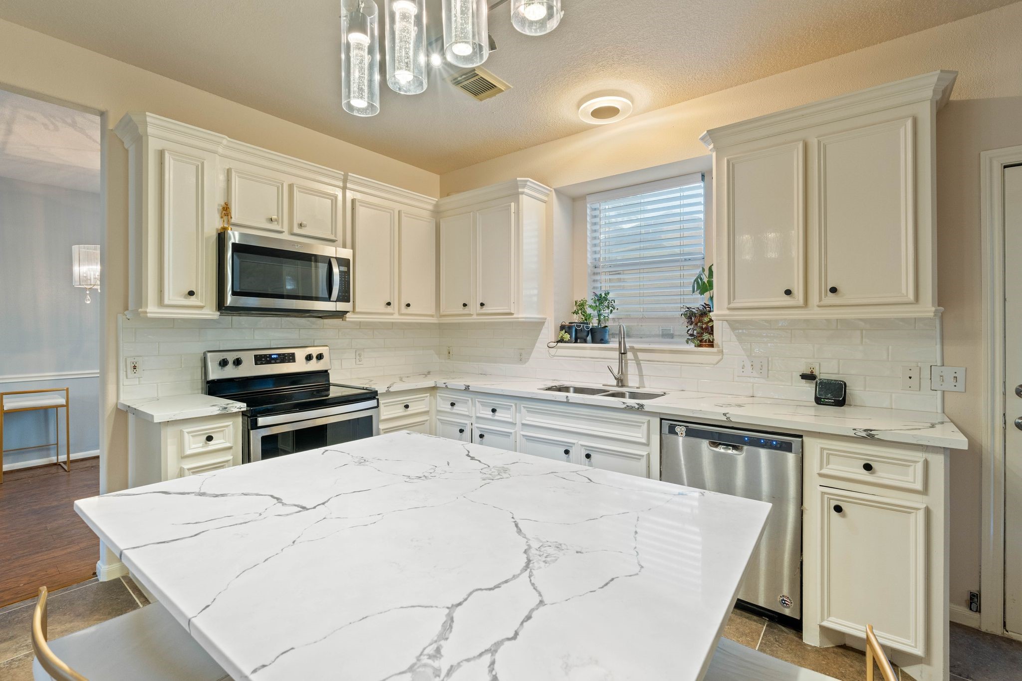 1908 Northampton Drive Conroe, TX 77303 - Photo 17 of 44 a kitchen with stainless steel appliances granite countertop a stove a sink dishwasher a microwave oven a stove with white cabinets and wooden floor