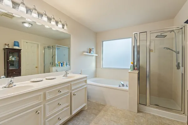a bathroom with a double vanity sink mirror double and shower