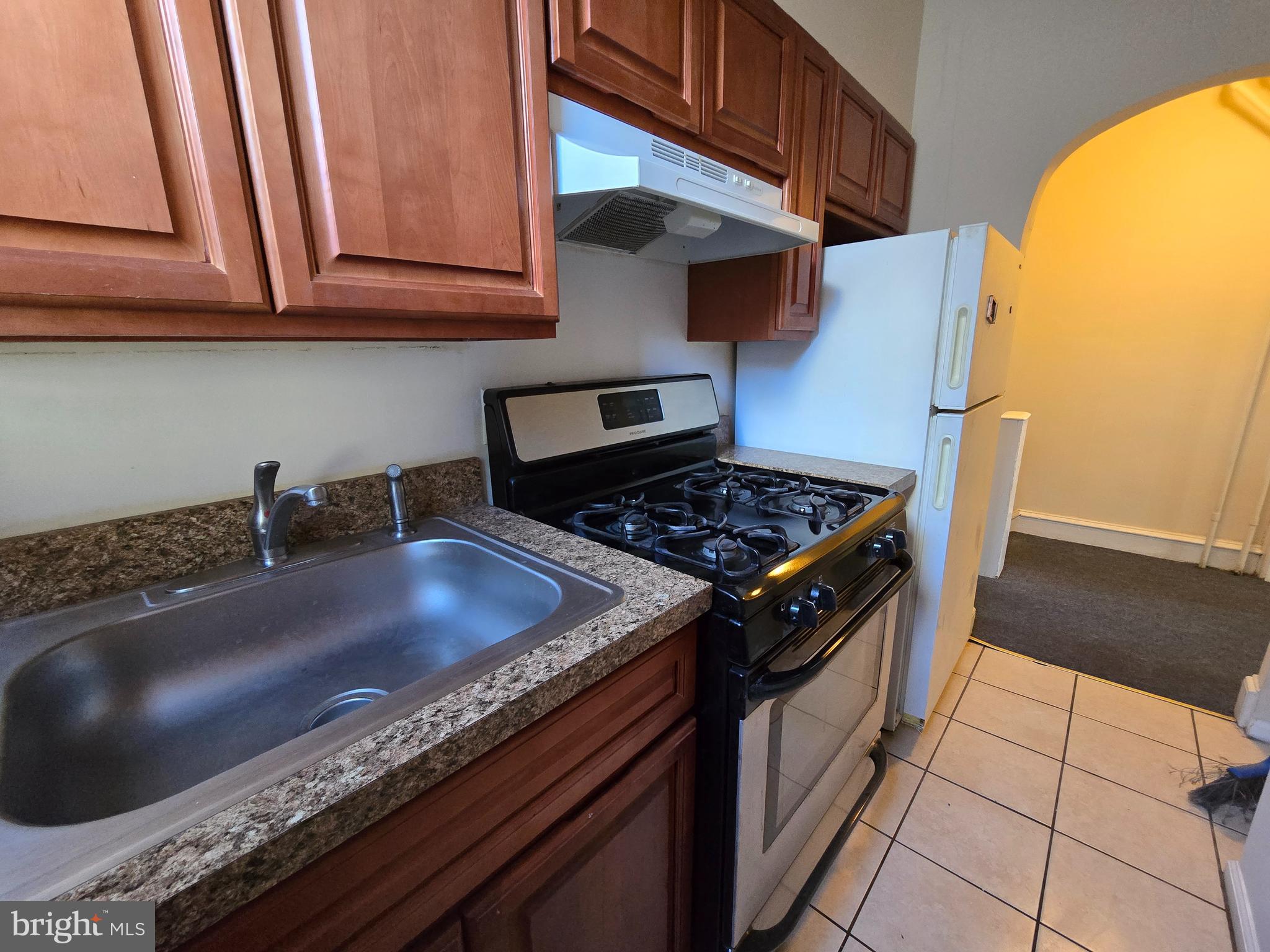 4820 Griscom Street, Unit B Philadelphia, PA 19124 - Photo 2 of 17 a kitchen with granite countertop a stove and a sink