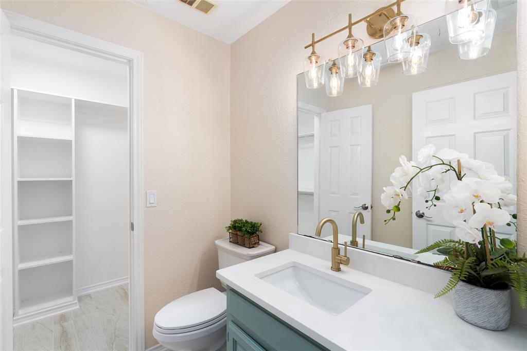 7016 Harvey Lane Plano, TX 75025 - Photo 18 of 26 a bathroom with a sink a toilet and a mirror