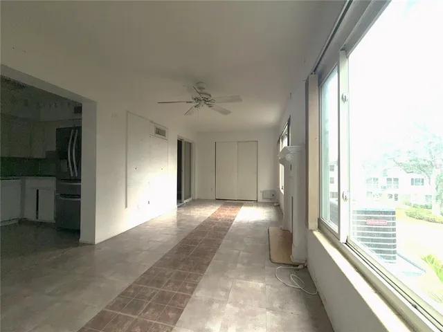 a view of a hallway with an empty room and a window