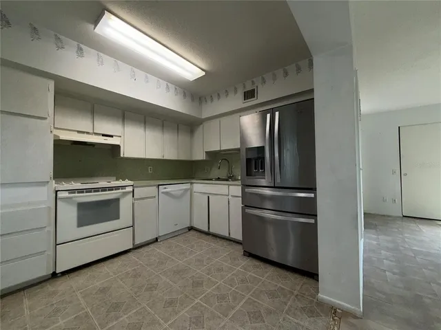 a kitchen with a stove top oven and refrigerator