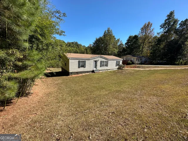 a view of a house with yard and sitting area