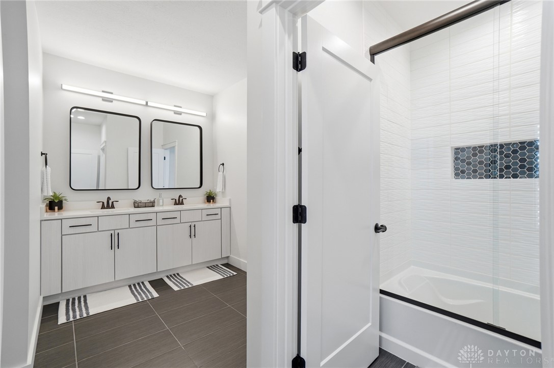 1247 Normandy Rue Dayton, OH 45458 - Photo 33 of 76 This bright bathroom features a spacious double vanity and a sleek shower-tub combination.