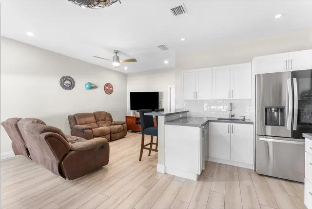 a kitchen with stainless steel appliances a dining table chairs stove and refrigerator