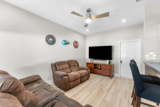 a living room with furniture a ceiling fan and a window