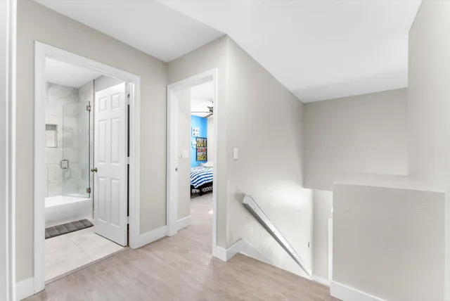 a bedroom with a bed a flat screen tv and a ceiling fan